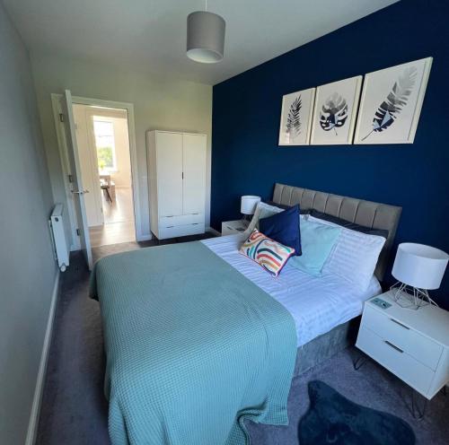 珀斯Stunning 2 Bedroom River View Apartment的一间卧室配有一张带蓝色墙壁的大床