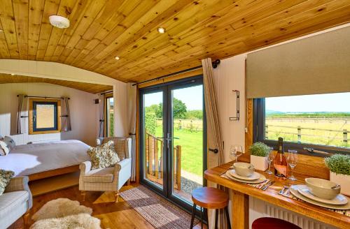 WichenfordAbberley Shepherds Hut - Ockeridge Rural Retreats的一间卧室配有一张床,享有田野美景