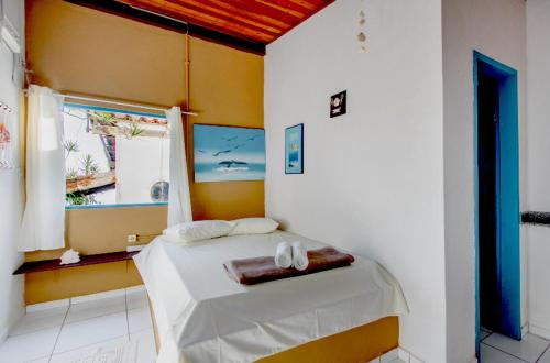阿拉夏奇巴海滩Pousada Canto do Mar Ilha Grande的一间卧室配有一张带白色床单的床和一扇窗户。