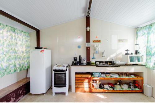 阿拉夏奇巴海滩Pousada Canto do Mar Ilha Grande的厨房配有白色冰箱和炉灶。