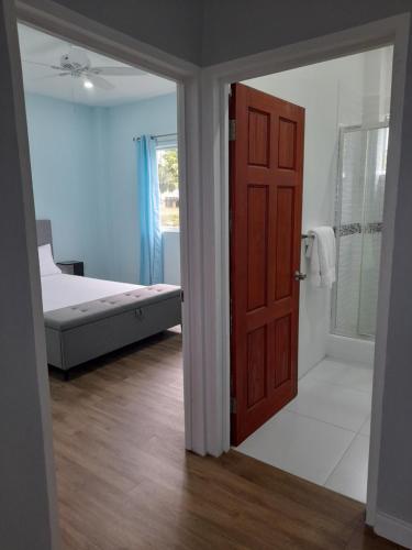 昂斯拉雷区Serenity Seaview Suite的一间卧室设有一张床和一个开放式门