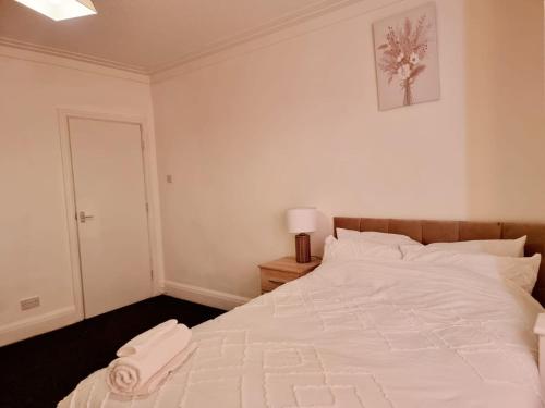 BalbyLilies Lodge的卧室配有一张白色大床,上面有毛巾