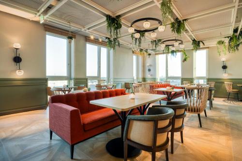 维也纳Citadines Danube Vienna的一间带沙发和桌椅的餐厅