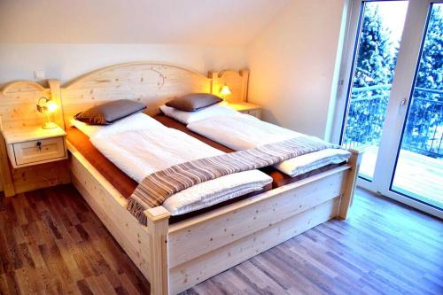 圣迈克尔隆高Luxury villa 2-10 people with Sauna close to Lift / FIS Ski slope的一间卧室配有一张木床和两个枕头