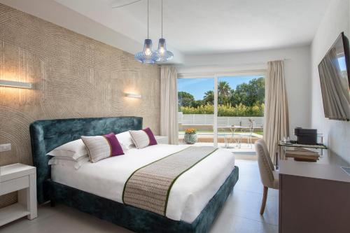 哥斯达雷Villa Escargot Luxury in Costa Rei Beach的一间卧室配有一张床、一张书桌和一个窗户。