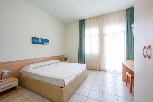 利多迪耶索罗基内弗拉酒店的一间卧室设有一张床和一个大窗户