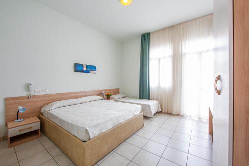 利多迪耶索罗基内弗拉酒店的一间卧室设有两张床和窗户。