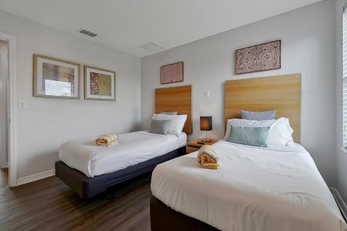 基西米Encantada Resort Vacation Townhomes by IDILIQ的白色墙壁客房的两张床