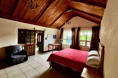 圣胡安拉拉古纳Casa I’x (Jaguar)的一间卧室配有红色的床和椅子