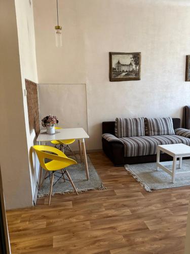 考纳斯Sija's house的客厅配有沙发、桌子和黄色椅子
