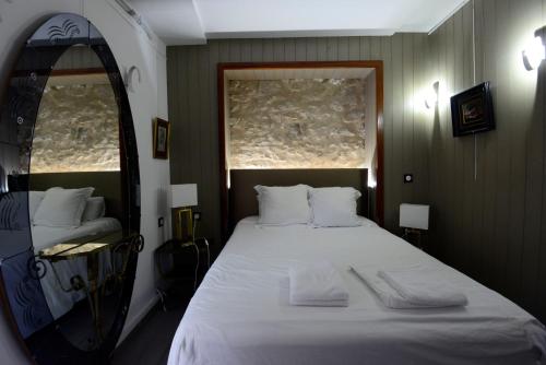 桑斯Hotel de la muraille de sens的卧室配有一张带镜子的白色大床