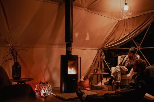 斯莱戈Teapot Lane Glamping - Adults only的一群人坐在帐篷里,火上浇油