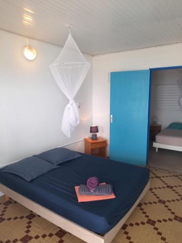Rivière-PiloteTI PARADIS DE l'ANSE FIGUIER VILLA voir site vacances en martinique的一间卧室配有一张带蓝色床罩的床