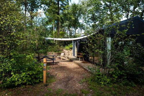 宁斯佩特Vague Luxurious Tiny House Luxe Wellness, Spa Bad,Beamer, Veluwe的树林中的小屋,配有野餐桌和帐篷