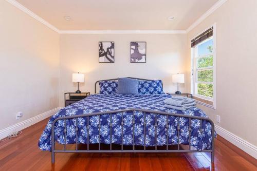 瓦列霍Lavender house near Napa and San Francisco的一间卧室配有一张带蓝色棉被的床和窗户。