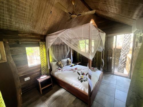 宾当AbCa溪流山林小屋的一间卧室配有一张带蚊帐的床