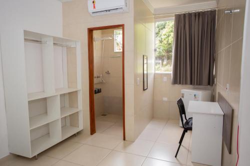 阿拉沙Ribeiro Suit's Hotel的一间带卫生间和水槽的浴室以及一张书桌。