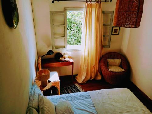 舍夫沙万Dar SBAA的一间卧室设有一张床、一个窗口和一把椅子