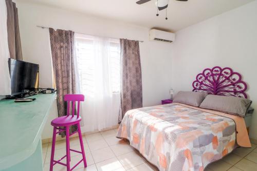 马萨特兰Habitación Privada en Zona Dorada的一间卧室配有一张床和两张紫色凳子
