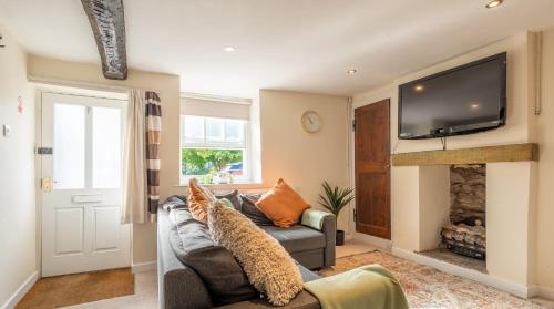 肯德尔Wee Toad Hole Heart of Kendal - Cottage sleeps 4-6 - Dogs Welcome的客厅设有灰色的沙发和壁炉