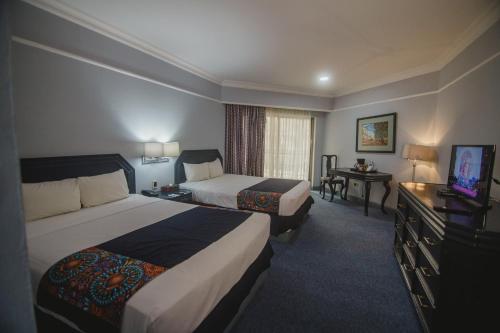 特皮克Nk Hotel Nekié Tepic的酒店客房设有两张床和电视。
