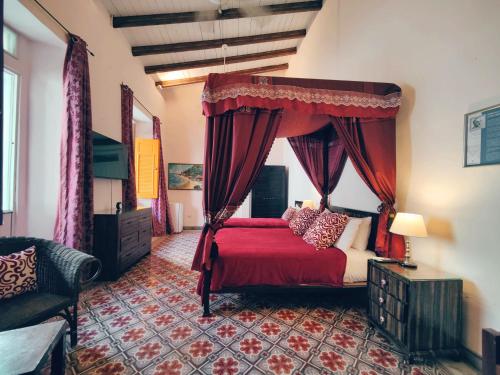 圣多明各Casa Sánchez Hotel的一间卧室配有红色的床和天篷