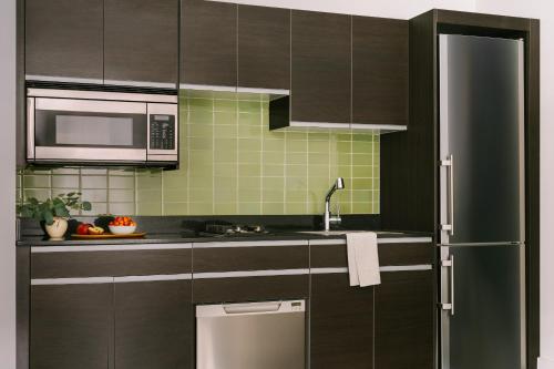 纽约Sonder at One Platt的厨房配有棕色橱柜和不锈钢冰箱