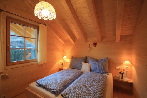 达米尔斯Feriendorf Walserland的一间卧室设有一张床、一个窗户和一个吊灯。