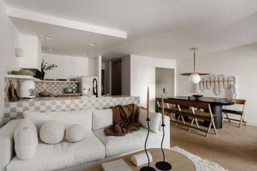 惠斯勒Ski-in/Ski-out Intentionally Designed Ski Lodge的一间带白色沙发的客厅和一间厨房