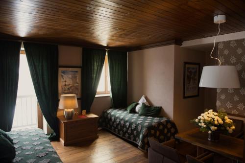 布勒伊-切尔维尼亚萨莫瓦宾馆的一间卧室配有床和绿色窗帘