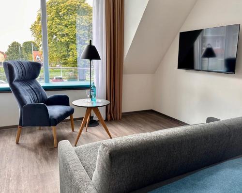 威廉港Hotel Schöne Aussicht的客厅配有沙发、椅子和桌子