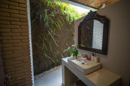 乌布普利巴育旅馆的一间带水槽和镜子的浴室