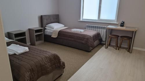 波尔塔瓦Гостьовий Будинок Апартаменти в тихому центральному районі Полтави Смарт-квартири的客房设有两张床、一张桌子和一张书桌。