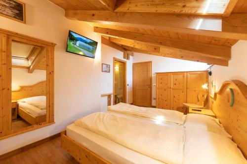菲耶梅堡科拉迪尼食宿酒店的一间带两张床的卧室,位于木天花板的房间