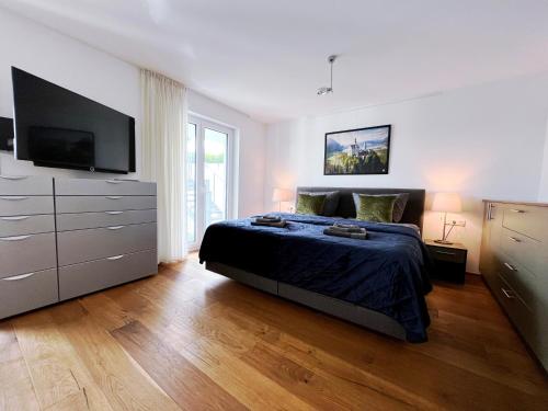 海尔布隆Luxuriöses 130qm Apartment mit Balkon im Zentrum,Parkplatz的一间卧室配有一张床和一台平面电视