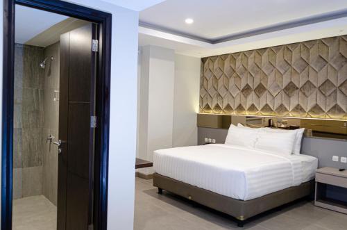 美娜多Arcadia Hotel Manado的一间卧室配有一张特大号床和淋浴
