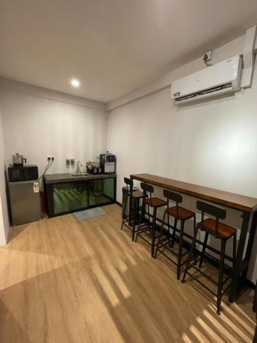 Kampong Gadong22 Hours Hostel的带吧台的房间,带凳子和厨房