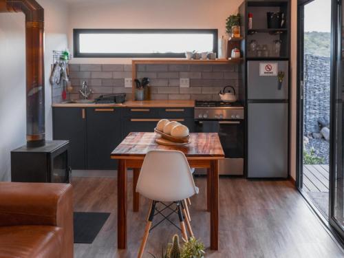 海德堡Aviary Hills Luxury Hideaway的带木桌的厨房和带冰箱的厨房。