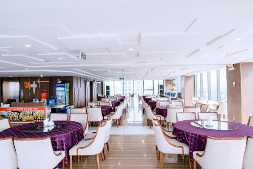 荣市Khách sạn Toàn Thắng Stone的一间用餐室,配有紫色的桌子和白色的椅子