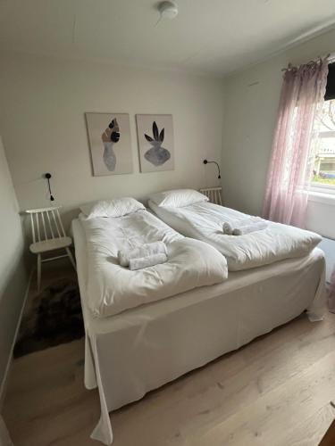 KvaløyaLena Apartment Tromsø的一间卧室配有两张带白色床单的床