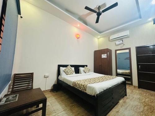 齐拉克普尔Hotel Sunkriti Resort的一间卧室配有一张床和吊扇