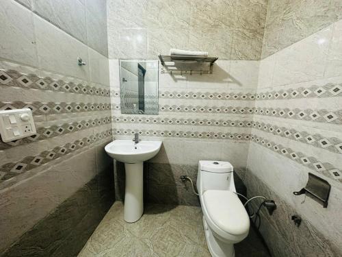 齐拉克普尔Hotel Sunkriti Resort的一间带卫生间和水槽的浴室