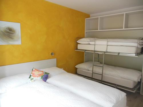 Prato特恩西亚住宿加早餐旅馆的一间卧室设有两张床和黄色的墙壁
