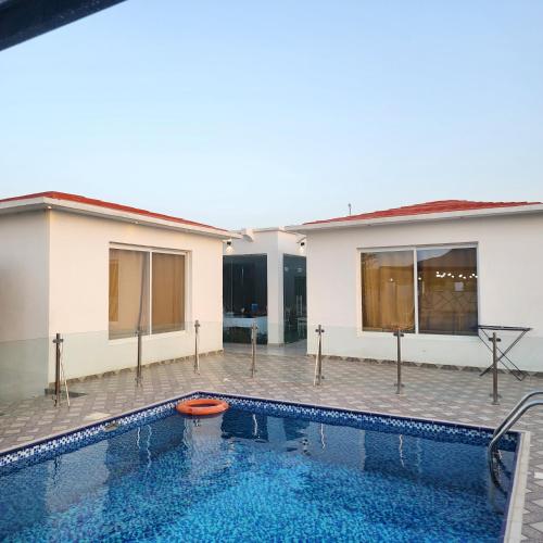 DawwahWadi Bani Khalid - Al Joud Green Hostel的房屋前的游泳池