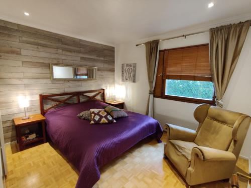 埃斯波Villa Jupperi Espoossa的一间卧室配有一张紫色的床和一把椅子