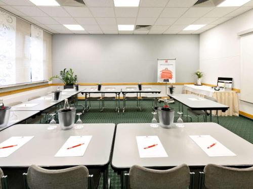 科隆科隆中心宜必思酒店的一个配有桌椅的空教室