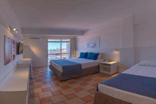 弗洛里亚诺波利斯Express Floripa Residence的酒店客房设有两张床和一个阳台。