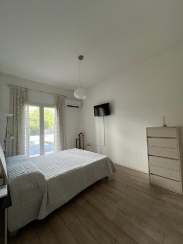 加尔达湖滨Appartamento Noi Due的一间卧室配有一张床、梳妆台和电视。