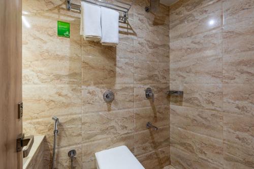 孟买LOTUS GRAND HOTEL MUMBAI的带淋浴、卫生间和盥洗盆的浴室