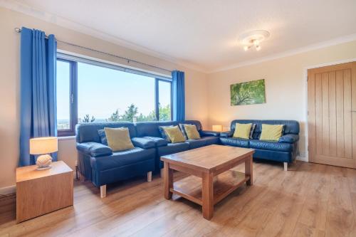 普利斯坦丁Offa's Lodge Family home quiet area with sea views的客厅配有蓝色的沙发和桌子